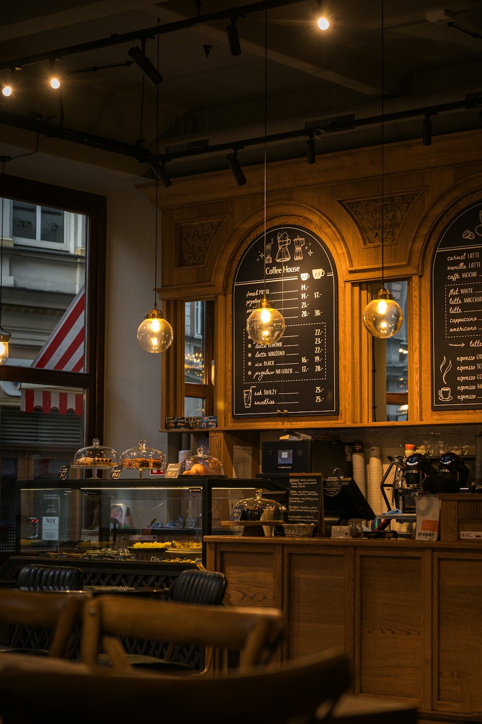Pastries and coffee menu boards displayed on a wooden counter.