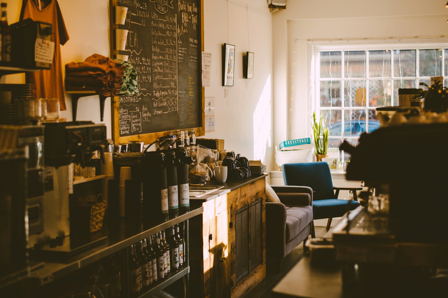 Coffee shop counter with a menu board and seating area.