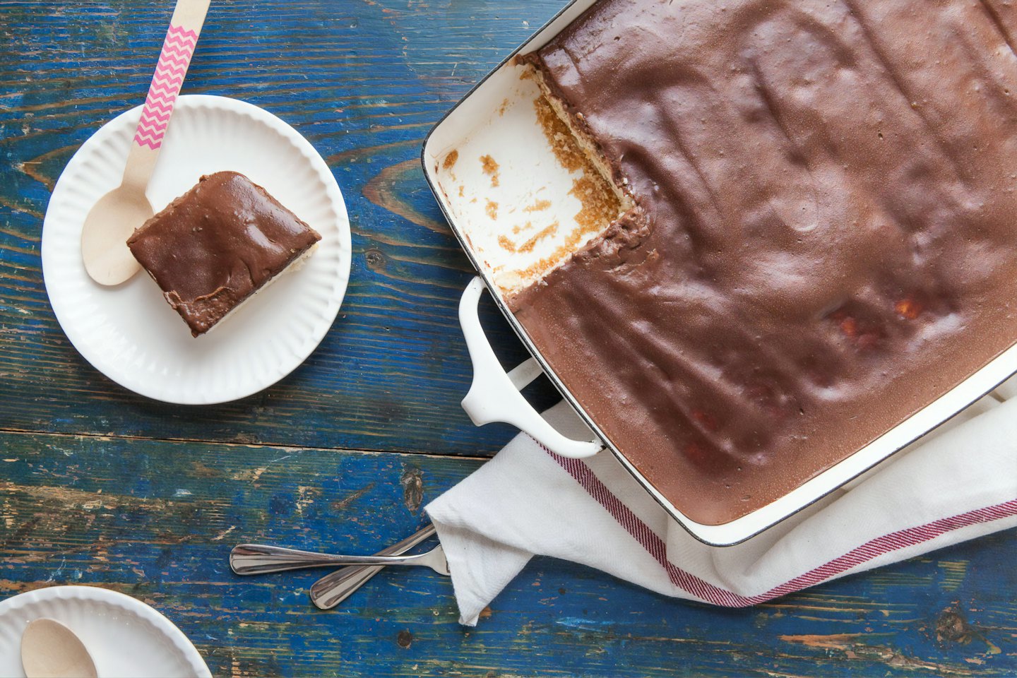 Slice of chocolate cake on a blue table.